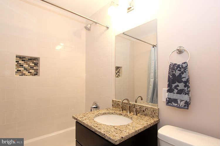 8129 Bullneck Road Baltimore, MD 21222 - Photo 20 of 30 a bathroom with a granite countertop sink toilet and shower