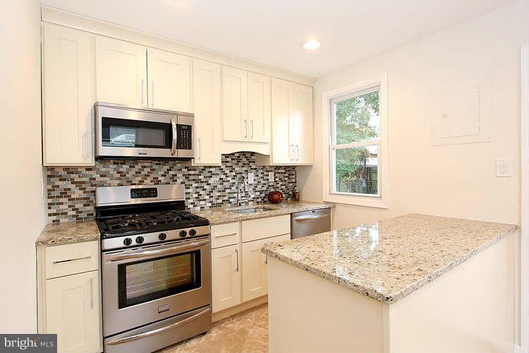8129 Bullneck Road Baltimore, MD 21222 - Photo 3 of 30 a kitchen with stainless steel appliances kitchen island granite countertop a sink stove and microwave