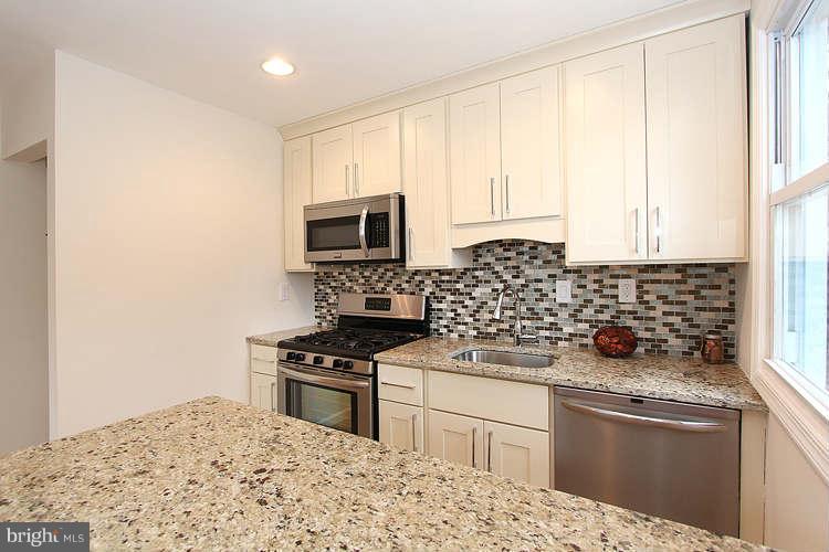 8129 Bullneck Road Baltimore, MD 21222 - Photo 4 of 30 a kitchen with granite countertop a stove a sink and a microwave
