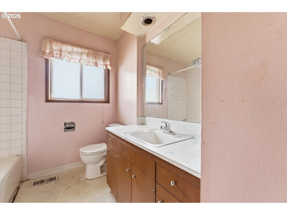 12333 Southeast Madison Street Portland, OR 97233 - Photo 13 of 28 a bathroom with a granite countertop sink toilet a large mirror and a window