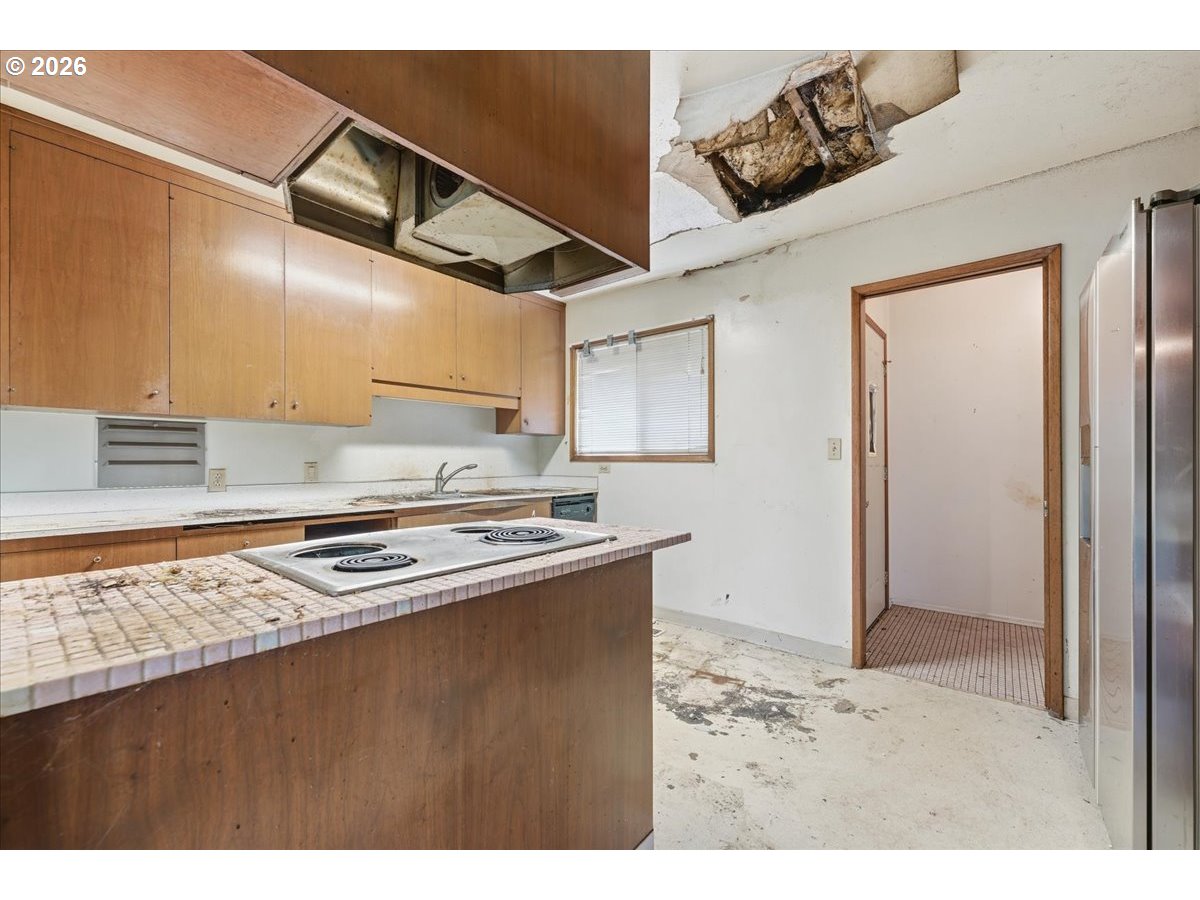 12333 Southeast Madison Street Portland, OR 97233 - Photo 7 of 28 a kitchen with a stove and a refrigerator