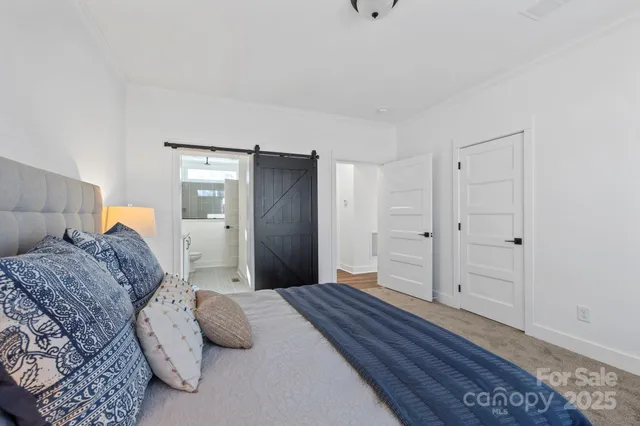 a bedroom with a large bed and wooden floor