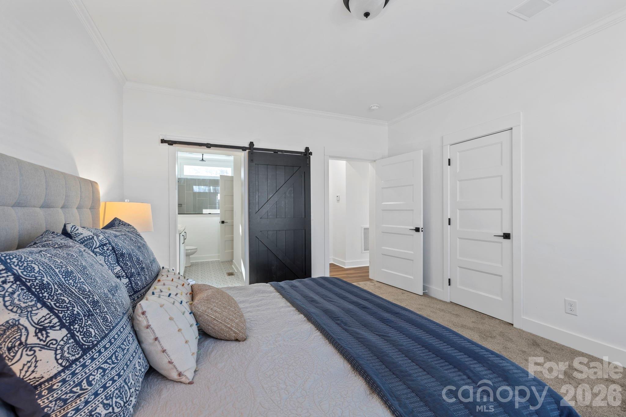 205 Southern Charm Road Arden, NC 28704 - Photo 16 of 34 a bedroom with a large bed and wooden floor