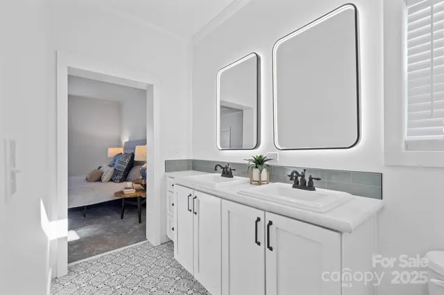 a en suite bathroom with a double vanity sink and a mirror