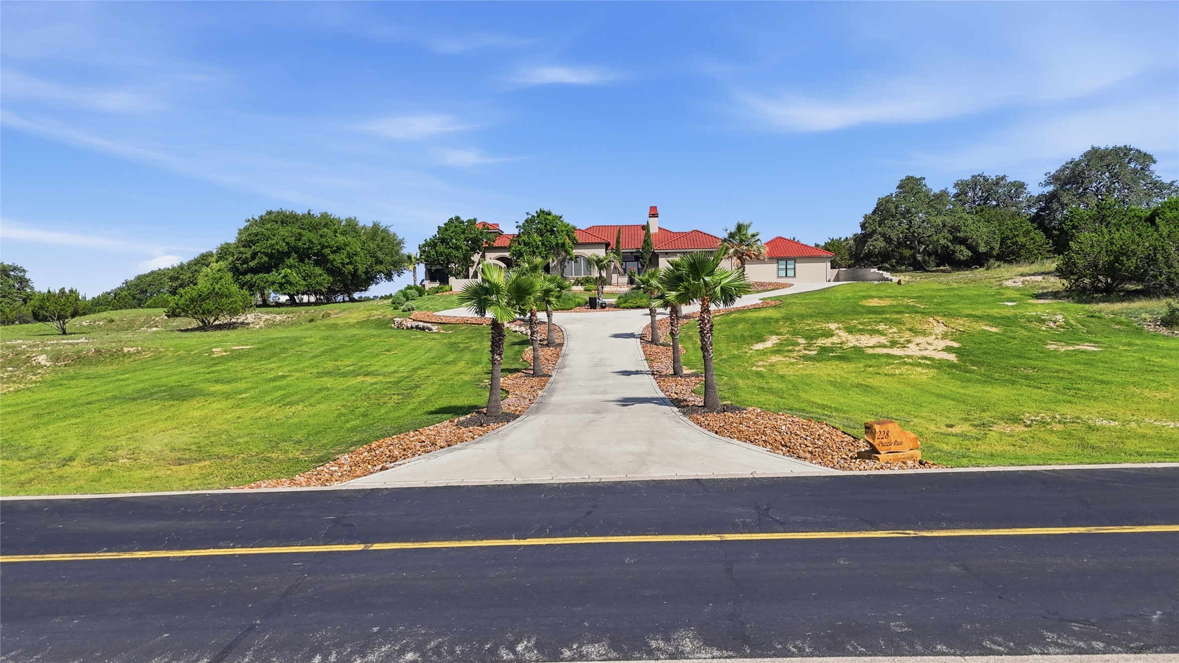 228 Puzzle Pass Spring Branch, TX 78070 - Photo 34 of 35 Set well back from the road, a palm-lined drive creates a private and impressive approach to the home.