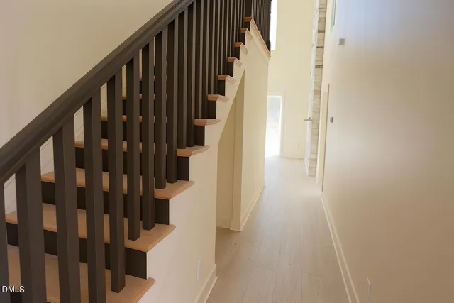 a view of staircase with wooden floor and white walls