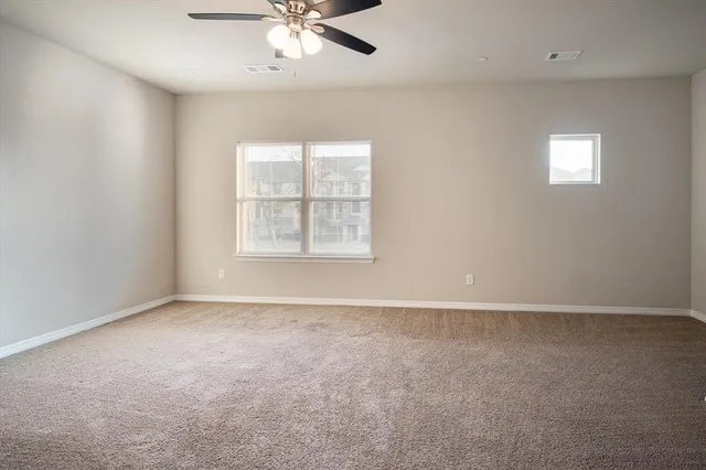 an empty room with windows and fan