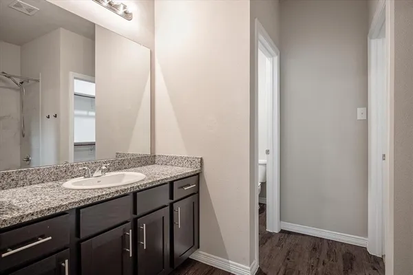 a bathroom with a granite countertop sink and a mirror