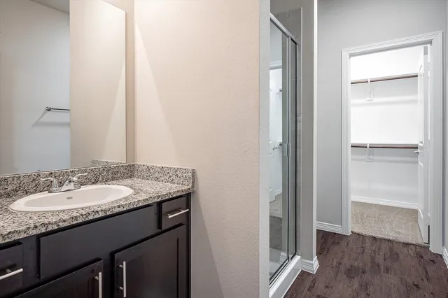 a bathroom with a granite countertop sink and a mirror