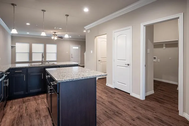 an open kitchen with a refrigerator and a sink