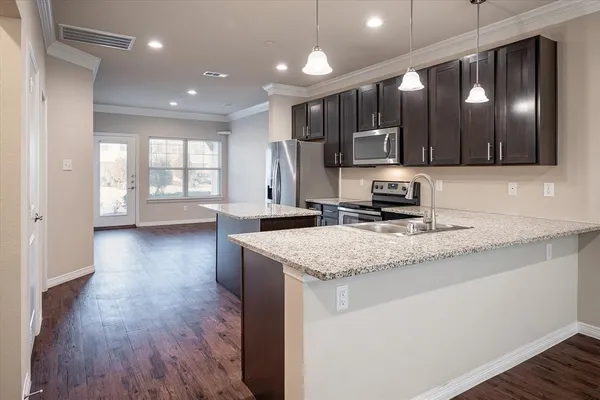a kitchen with stainless steel appliances granite countertop a sink stove and wooden floor
