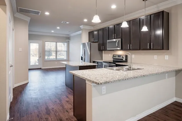 a kitchen with stainless steel appliances granite countertop a sink stove and wooden floor
