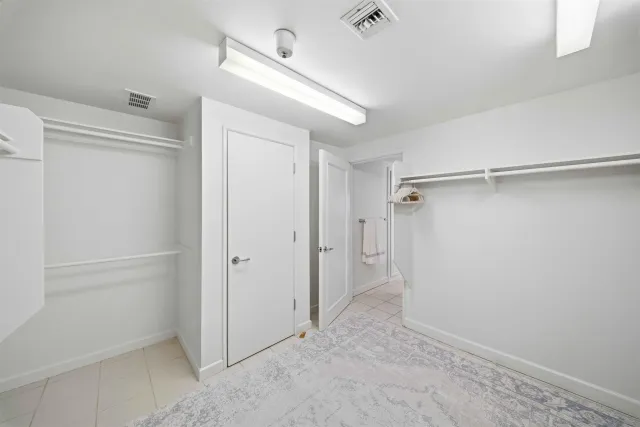 a spacious bedroom with a bed and a lamp