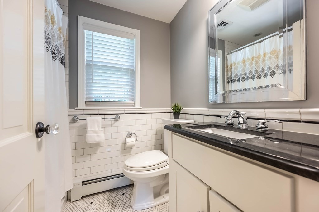 1 Rennie Drive Andover, MA 01810 - Photo 31 of 39 a bathroom with a granite countertop sink a toilet and a shower curtain