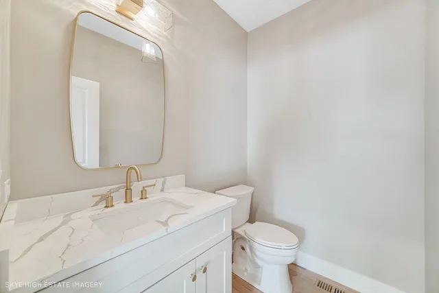 a bathroom with a sink vanity mirror and toilet