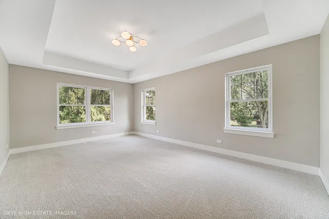 a view of an empty room with a chandelier fan