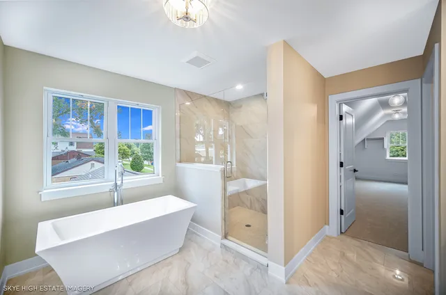 a bathroom with double vanity sink a two mirror a window and a bathtub