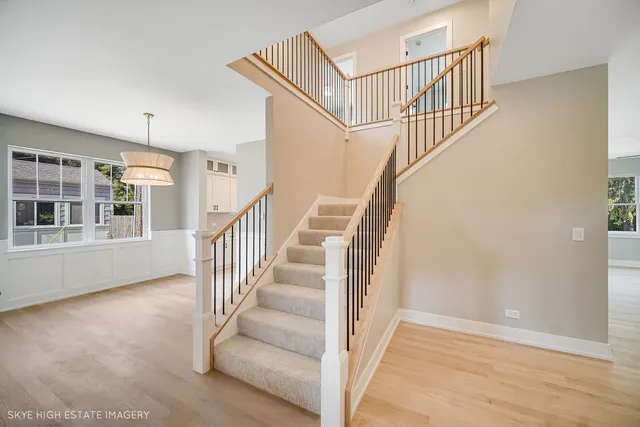 a view of staircase with lots of frames on wall and a window