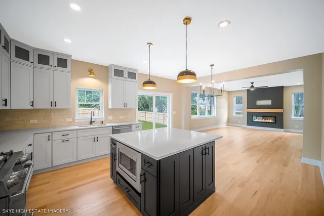 a kitchen with a stove center island and wooden floor