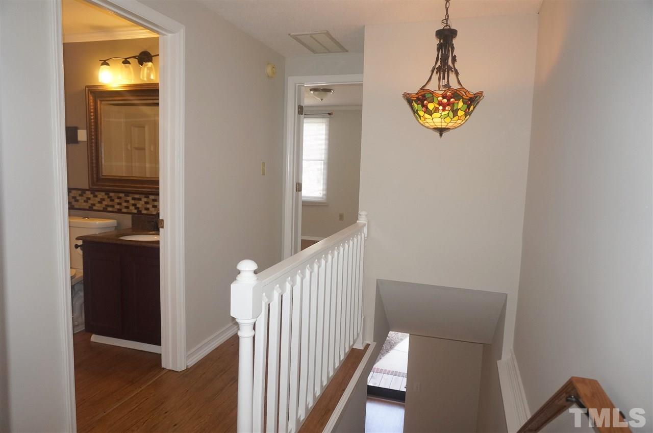 7709 Crown Crest Court Raleigh, NC 27615 - Photo 12 of 21 a view of a hallway with wooden floor and a bathroom