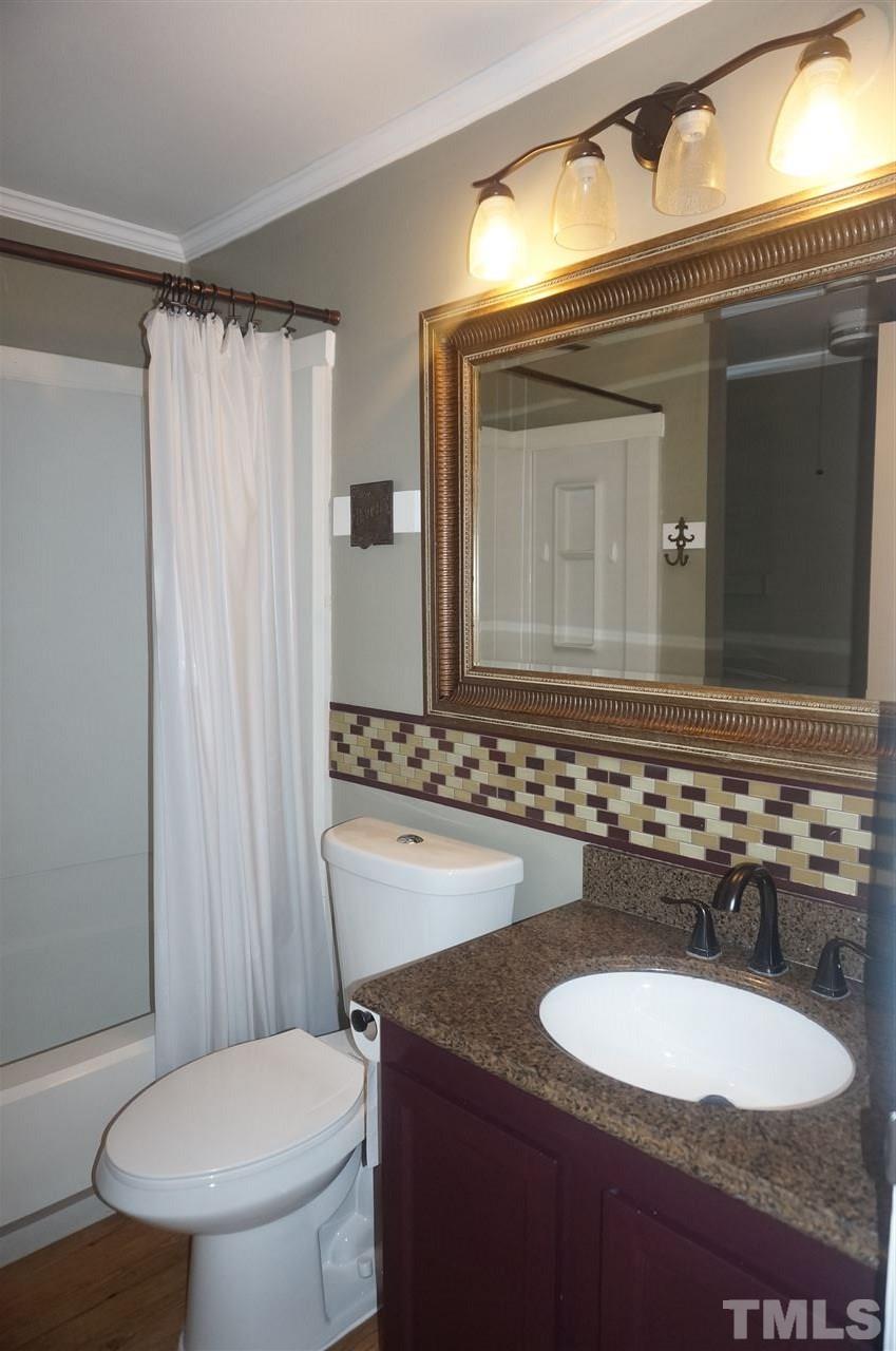 7709 Crown Crest Court Raleigh, NC 27615 - Photo 13 of 21 a bathroom with a granite countertop toilet sink and mirror