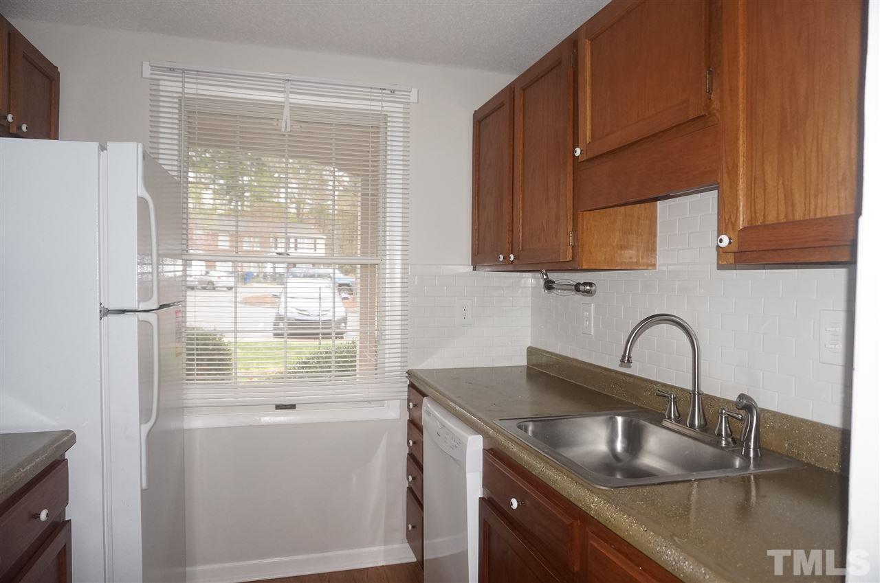 7709 Crown Crest Court Raleigh, NC 27615 - Photo 5 of 21 a kitchen with granite countertop a sink stainless steel appliances and cabinets