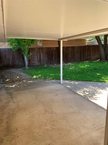 a view of a house with backyard and wooden fence