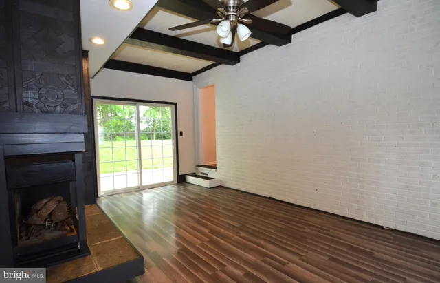 a view of an empty room with a fireplace and a window