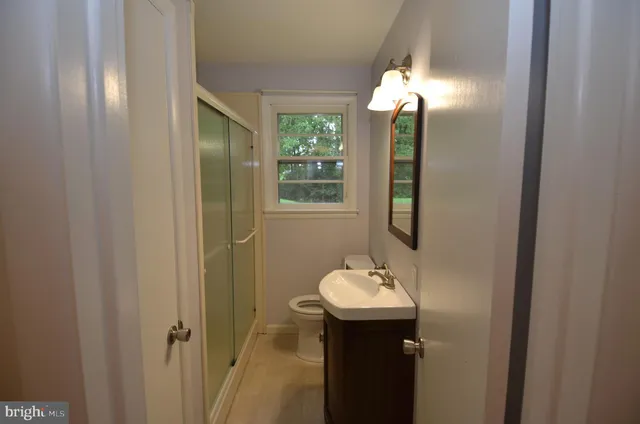 a bathroom with a sink and mirror with window