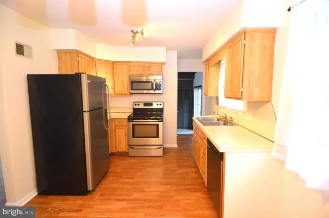 a kitchen with stainless steel appliances granite countertop a refrigerator and a sink