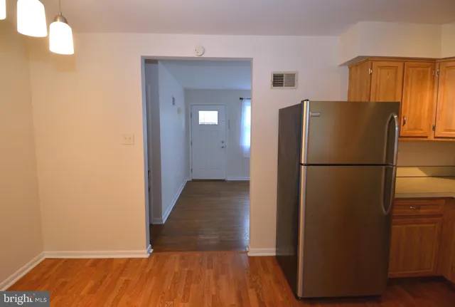 a view of a kitchen with wooden floor and a refrigerator