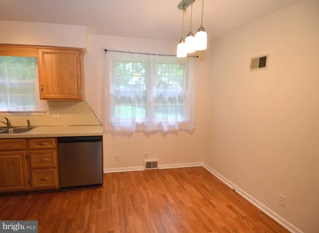a kitchen with a wooden floor and a large window