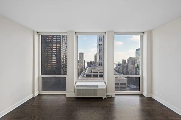 a view of a room with wooden floor swimming pool and windows