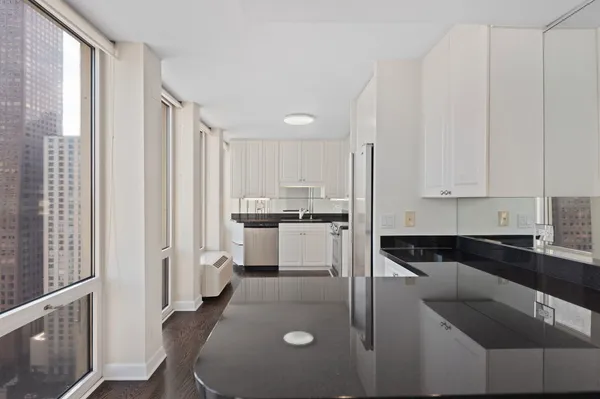 a kitchen with white cabinets and sink