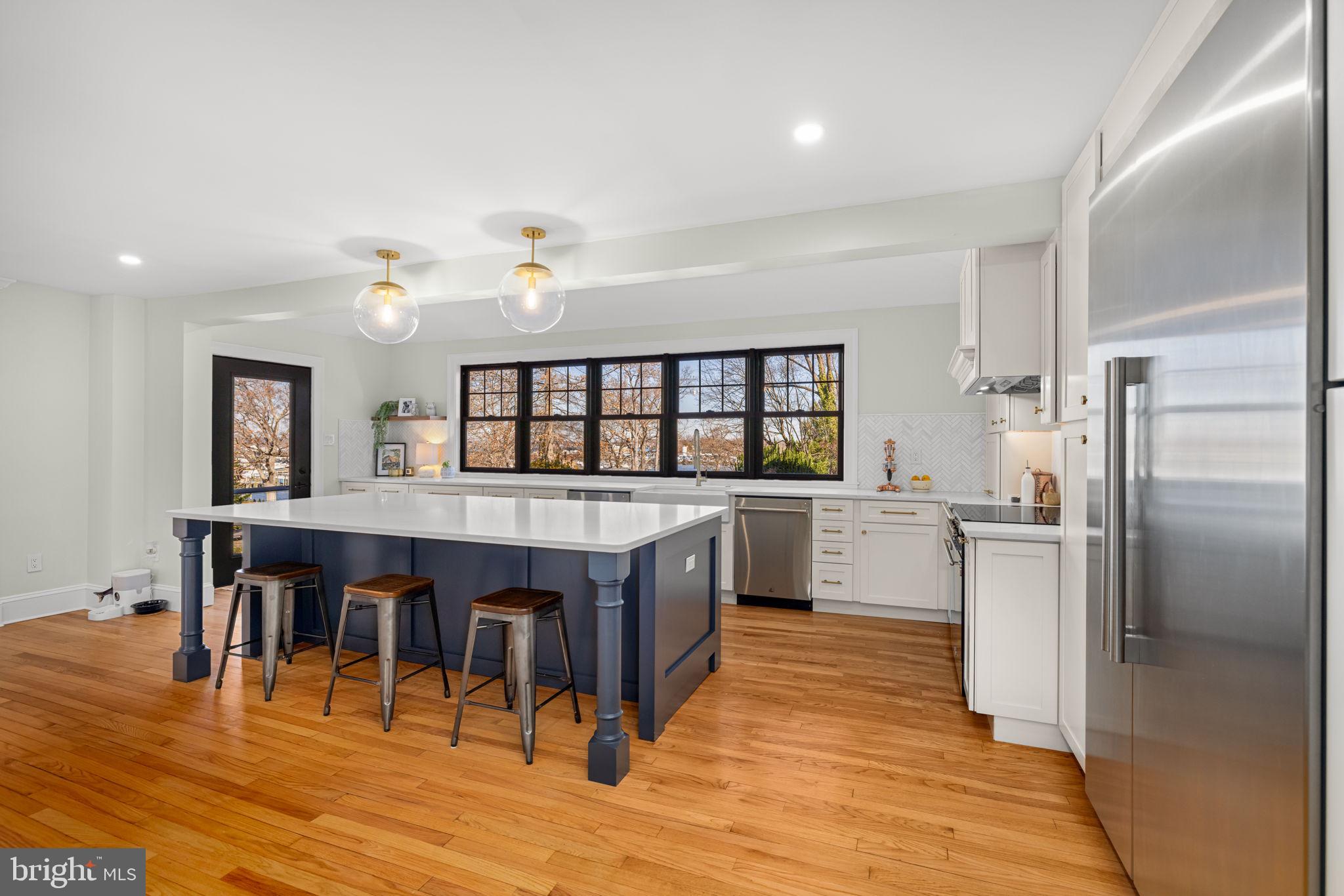 1138 Mayo Road Edgewater, MD 21037 - Photo 7 of 51 a kitchen with stainless steel appliances granite countertop a refrigerator a stove and a dining table with wooden floor