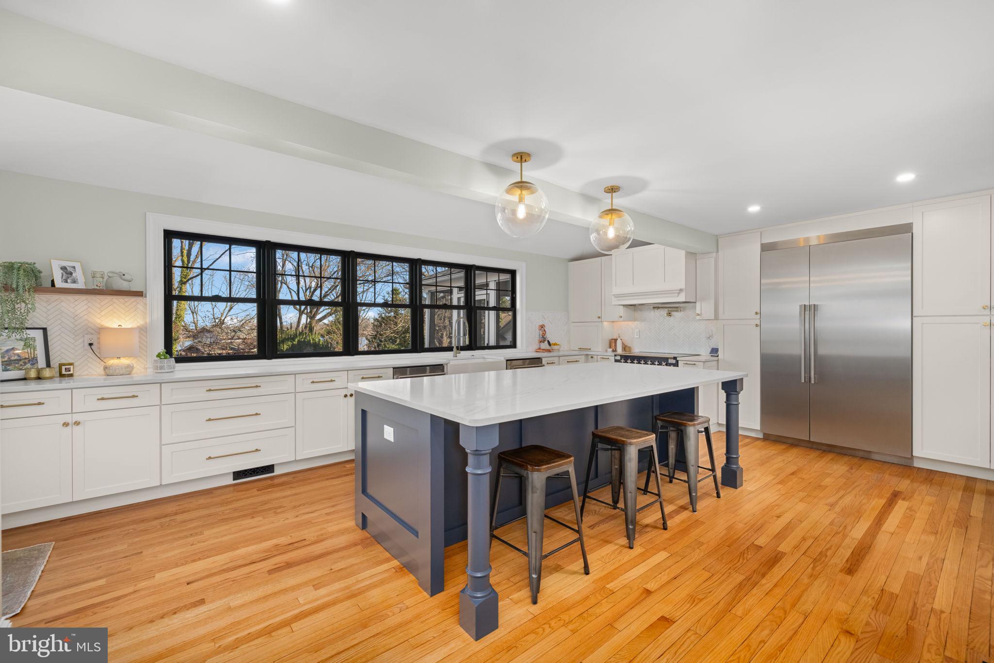 1138 Mayo Road Edgewater, MD 21037 - Photo 9 of 51 a kitchen with stainless steel appliances granite countertop a stove a refrigerator a sink dishwasher with a dining table and chairs with wooden floor