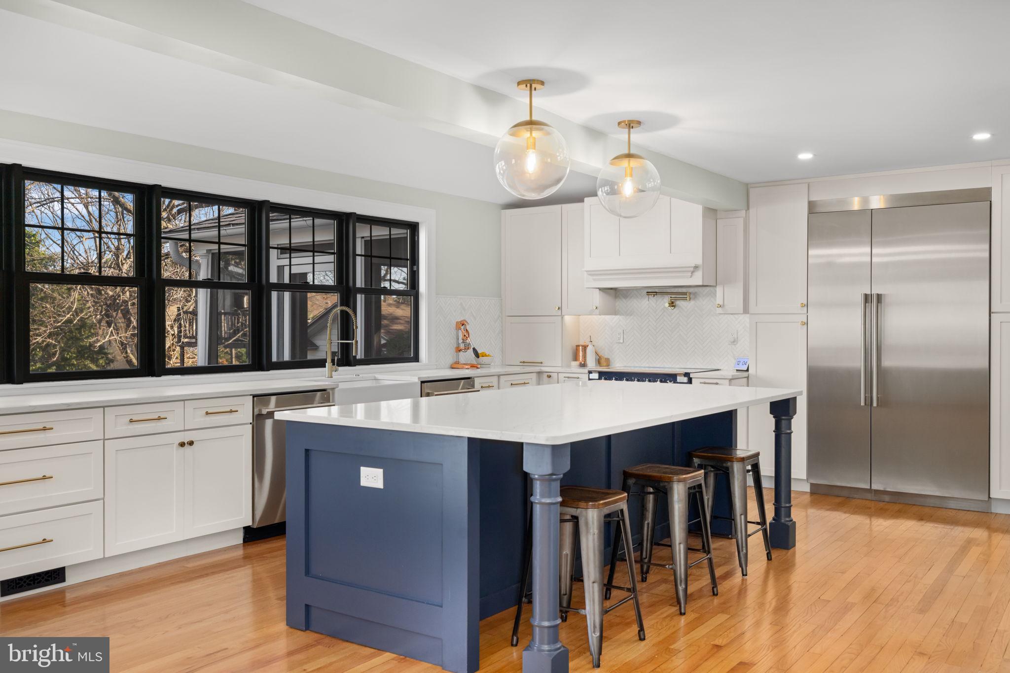 1138 Mayo Road Edgewater, MD 21037 - Photo 10 of 51 a kitchen with a stove a sink dishwasher a dining table and chairs with wooden floor