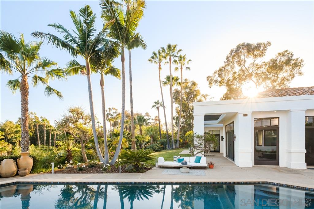7060 Rancho Cielo Rancho Santa Fe, CA 92067 - Photo 17 of 25 a view of a swimming pool with a lawn chairs under an umbrella