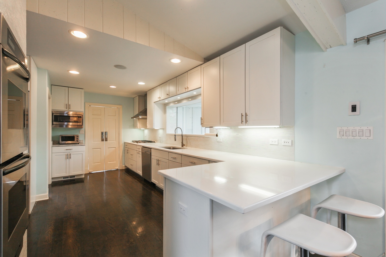 13 Meadowview Road Northfield, IL 60093 - Photo 6 of 23 a kitchen with a sink a stove a refrigerator and white cabinets with wooden floor