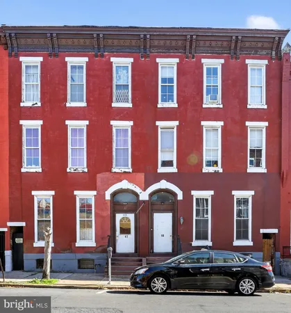 a front view of a building with parking space and windows