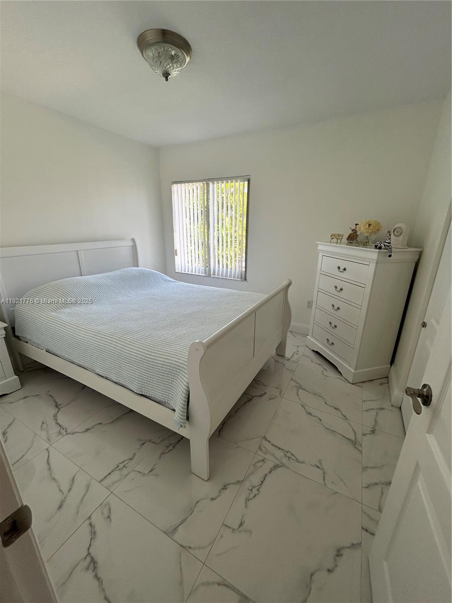 16620 Southwest 101st Terrace, Unit 1 Miami, FL 33196 - Photo 1 of 13 a bed sitting in a room next to a window