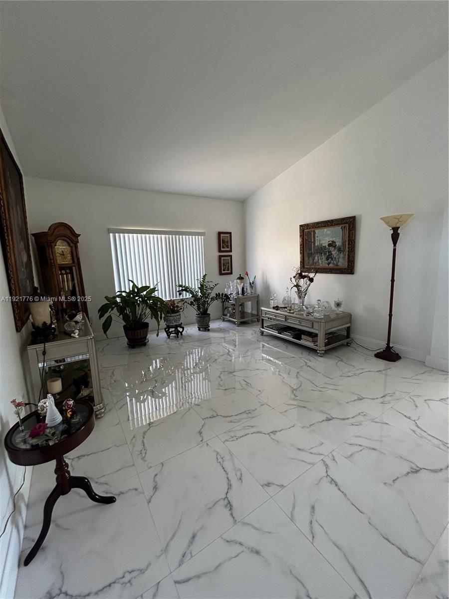 16620 Southwest 101st Terrace, Unit 1 Miami, FL 33196 - Photo 12 of 13 a living room with furniture a couch and a flat screen tv