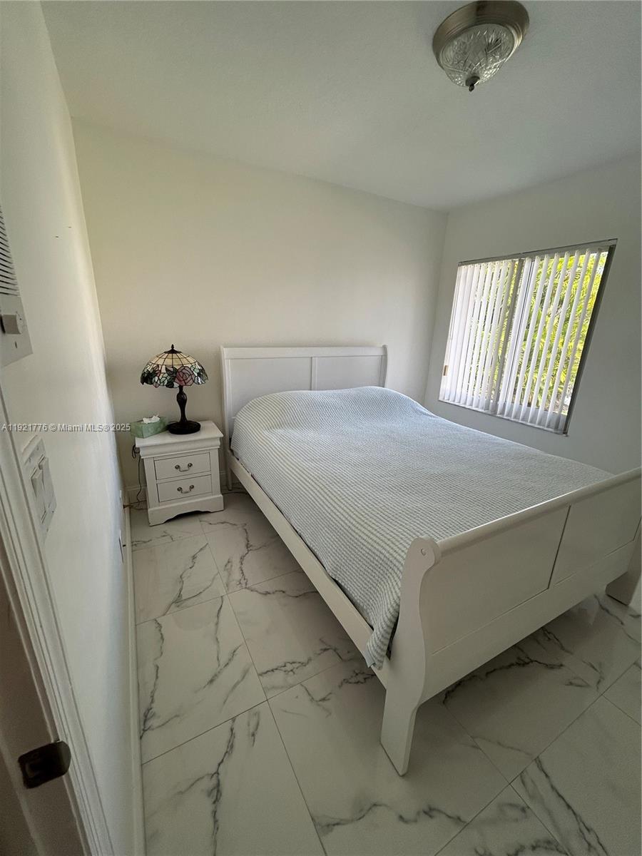 16620 Southwest 101st Terrace, Unit 1 Miami, FL 33196 - Photo 2 of 13 a bedroom with a bed and window