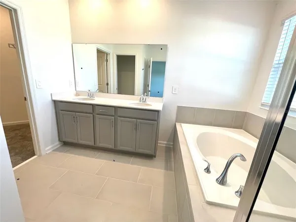 a bathroom with a tub sink and mirror