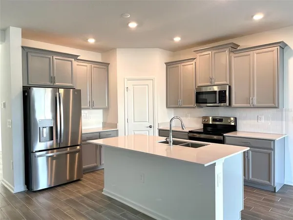 a kitchen with kitchen island a sink stainless steel appliances and cabinets