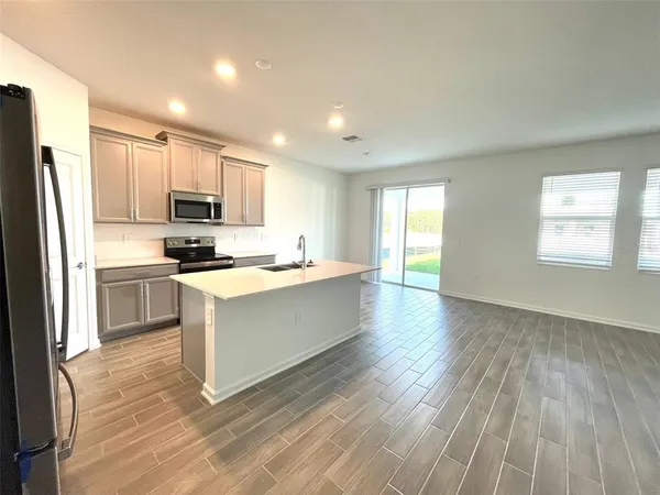 a kitchen with stainless steel appliances a refrigerator sink and microwave
