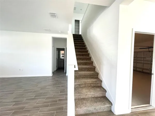 a view of a hallway with wooden floor and staircase