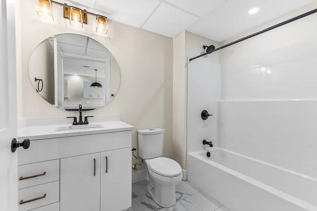 a bathroom with a sink a toilet and a mirror