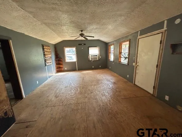 a view of a hallway with wooden floor and a living room