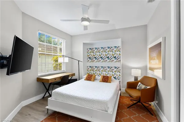 a bedroom with a bed and a flat screen tv